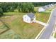 Aerial view of a white two story home with green lawn in a beautiful tree lined community at 294 Ralph Still Rd, Dacula, GA 30019
