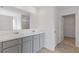 Bathroom boasts double sinks with marble countertops, grey shaker cabinets, and access to walk-in closet at 294 Ralph Still Rd, Dacula, GA 30019