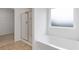 Bright bathroom features a glass shower stall, a separate soaking tub, and a frosted window at 294 Ralph Still Rd, Dacula, GA 30019