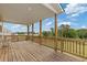 Covered back deck with wooden flooring, railings, and scenic outdoor view at 294 Ralph Still Rd, Dacula, GA 30019