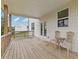 Covered back porch featuring wooden floors, railings, chairs and an exterior view at 294 Ralph Still Rd, Dacula, GA 30019