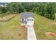 Aerial view of two-story home with large yard and long driveway surrounded by trees at 294 Ralph Still Rd, Dacula, GA 30019