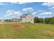 View of a two-story home featuring neutral siding, black shutters, a two-car garage, and a large grassy lawn at 294 Ralph Still Rd, Dacula, GA 30019