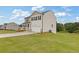 View of a two-story home featuring neutral siding, black shutters, a two-car garage, and a large grassy lawn at 294 Ralph Still Rd, Dacula, GA 30019
