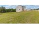View of a two-story home featuring neutral siding, black shutters, a two-car garage, and a large grassy lawn at 294 Ralph Still Rd, Dacula, GA 30019