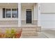 Close up of the front porch showcasing brick accents, white pillars, and a black front door with address number at 294 Ralph Still Rd, Dacula, GA 30019