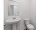 Half bathroom featuring a pedestal sink, toilet, and white walls at 294 Ralph Still Rd, Dacula, GA 30019