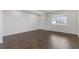 Living room showcasing laminate wood flooring, white walls, baseboards, and trim, and a window at 294 Ralph Still Rd, Dacula, GA 30019