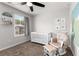 Bedroom featuring a crib, rocking chair, ceiling fan, and natural light from the window at 3723 Silvery Way, Powder Springs, GA 30127