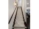 Bright staircase with carpet runner, dark wood treads and handrail leading to a white door at 721 Longleaf Ne Dr # 3, Atlanta, GA 30342