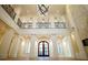 An expansive foyer with a second-floor balcony, decorative railings, white columns, and hardwood floors at 9675 Almaviva Dr, Alpharetta, GA 30022