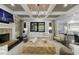 Bright living room featuring a stone fireplace, coffered ceilings, and large windows at 9675 Almaviva Dr, Alpharetta, GA 30022