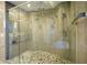 Luxurious glass-enclosed shower featuring marble-look tile, a mosaic stone floor, and dual shower heads at 9675 Almaviva Dr, Alpharetta, GA 30022