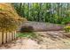 Large backyard featuring a stone retaining wall, mature trees, and a wooden fence at 62 Mount Vernon Cir, Atlanta, GA 30338