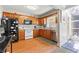 Kitchen with wooden cabinets, white appliances, and a tile floor, featuring access to an enclosed sunroom at 62 Mount Vernon Cir, Atlanta, GA 30338