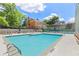 Outdoor community pool with ample seating and nearby tennis court on a sunny day, surrounded by lush greenery at 62 Mount Vernon Cir, Atlanta, GA 30338
