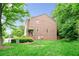 Large backyard with lush lawn, mature trees, and partial brick exterior, offering a private outdoor space at 1996 Cobblestone Ne Cir, Atlanta, GA 30319