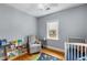 Bright Bedroom with hardwood floors, two windows, rocking chair, and a crib at 2486 Memorial Se Dr, Atlanta, GA 30317