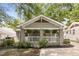 Charming bungalow with a welcoming front porch and well-maintained landscaping with black mulch at 2486 Memorial Se Dr, Atlanta, GA 30317