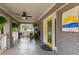 Inviting covered front porch featuring a ceiling fan, seating area, and bright yellow door with East Lake sign at 2486 Memorial Se Dr, Atlanta, GA 30317
