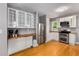 A well-lit kitchen featuring wooden floors, stainless steel appliances, and white cabinetry at 2486 Memorial Se Dr, Atlanta, GA 30317