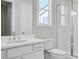 Well-lit bathroom features a white vanity with dual sinks, a toilet, and a glass-enclosed shower at 6660 Wallace Farms Dr, Cumming, GA 30028