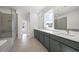 Modern bathroom featuring dual sinks, a large vanity, a glass-enclosed shower and a soaking tub at 6660 Wallace Farms Dr, Cumming, GA 30028