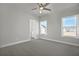 Bright bedroom with neutral carpet, ceiling fan and two windows that offer views of the neighborhood at 6660 Wallace Farms Dr, Cumming, GA 30028