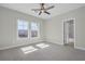 Bedroom featuring neutral carpet, two windows, ceiling fan, and a bathroom at 6660 Wallace Farms Dr, Cumming, GA 30028