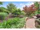 Professionally landscaped backyard with brick path, retaining walls, and trees at 209 Hearthstone Reach, Peachtree City, GA 30269