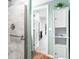 Marble tiled shower stall and linen cabinet in a bathroom with mint green walls at 209 Hearthstone Reach, Peachtree City, GA 30269