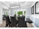 Bright dining room with large bay window, wood floors, seating for eight, and stylish lighting at 209 Hearthstone Reach, Peachtree City, GA 30269