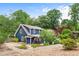 Exterior view of a well-maintained blue home with lush landscaping and backyard patio at 209 Hearthstone Reach, Peachtree City, GA 30269