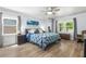 Spacious main bedroom featuring wood floors, ceiling fan, and serene backyard views from two windows at 209 Hearthstone Reach, Peachtree City, GA 30269