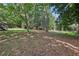 Large, grassy backyard with mature trees and a shed, providing ample space for outdoor activities and storage at 5421 Brownlee Rd, Stone Mountain, GA 30087