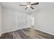 Bright bedroom features wood-look floors, a ceiling fan, and a closet with louvered doors at 5421 Brownlee Rd, Stone Mountain, GA 30087