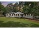 Charming one-story home with white brick exterior, manicured lawn, and welcoming front porch, exudes curb appeal at 5421 Brownlee Rd, Stone Mountain, GA 30087