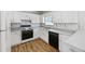 Well-lit kitchen with white cabinetry, modern appliances, and laminate floors at 9511 Rollinghills Dr, Jonesboro, GA 30238