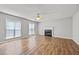 Bright living room with fireplace, ceiling fan, and wood laminate flooring at 9511 Rollinghills Dr, Jonesboro, GA 30238