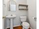 Bathroom features a pedestal sink, wood shelves, and wood-look flooring at 1363 Penhurst Dr, Lawrenceville, GA 30043