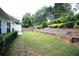 A beautifully landscaped backyard with a grassy area, mature trees, and a stone pathway at 260 Ruby Forest Pkwy, Suwanee, GA 30024