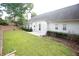 Spacious backyard with mature trees, a grassy area, and a white home exterior at 260 Ruby Forest Pkwy, Suwanee, GA 30024