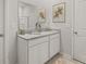 Bathroom featuring double sinks with granite countertop, white cabinets, and decorative wall art at 3178 Birdsong Ave, Covington, GA 30016