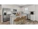 Modern kitchen with stainless steel appliances, white cabinets, a center island with seating, and wood floors at 3178 Birdsong Ave, Covington, GA 30016