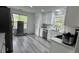 Modern kitchen features all-white cabinetry, stainless steel appliances, quartz countertops, and gray wood-look flooring at 51 Freedom Ne Dr, Cartersville, GA 30121