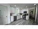 Modern kitchen features all-white cabinetry, stainless steel appliances, quartz countertops, and gray wood-look flooring at 51 Freedom Ne Dr, Cartersville, GA 30121