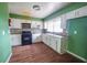 A kitchen featuring black appliances, white cabinetry and a mosaic tile backsplash at 1443 Snapfinger Rd, Decatur, GA 30032