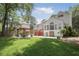 The house's backyard with a paver patio, dining set, upper deck, and grass yard at 1915 Milfield Cir, Snellville, GA 30078