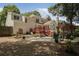 The house's backyard with a paver patio, dining set, upper deck, and rocky yard at 1915 Milfield Cir, Snellville, GA 30078