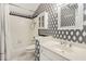 Updated bathroom with black and white wallpaper, a shower and vanity at 1915 Milfield Cir, Snellville, GA 30078